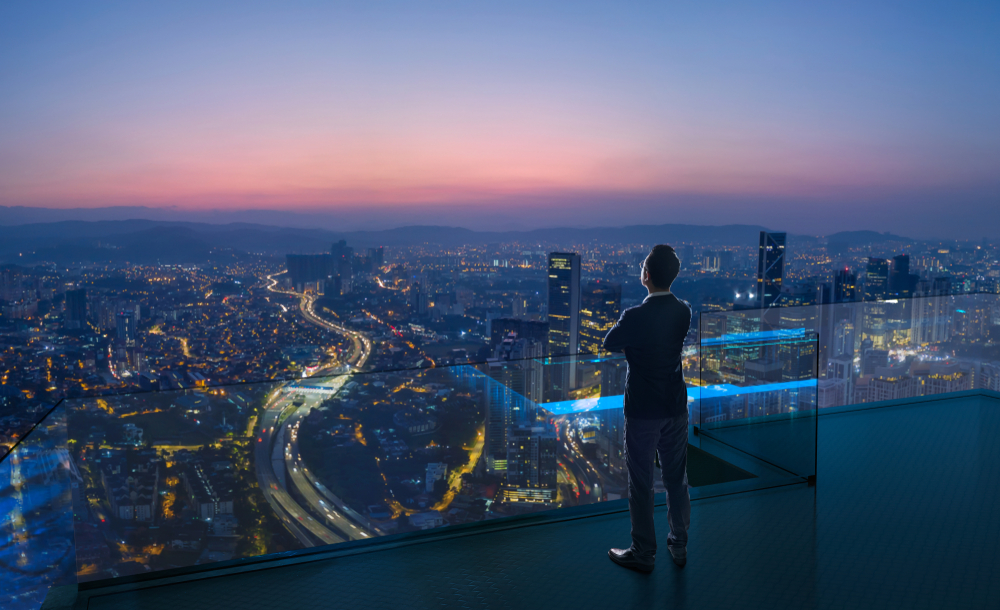 Businessman,Standing,On,Open,Roof,Top,Balcony,Watching,City,Night