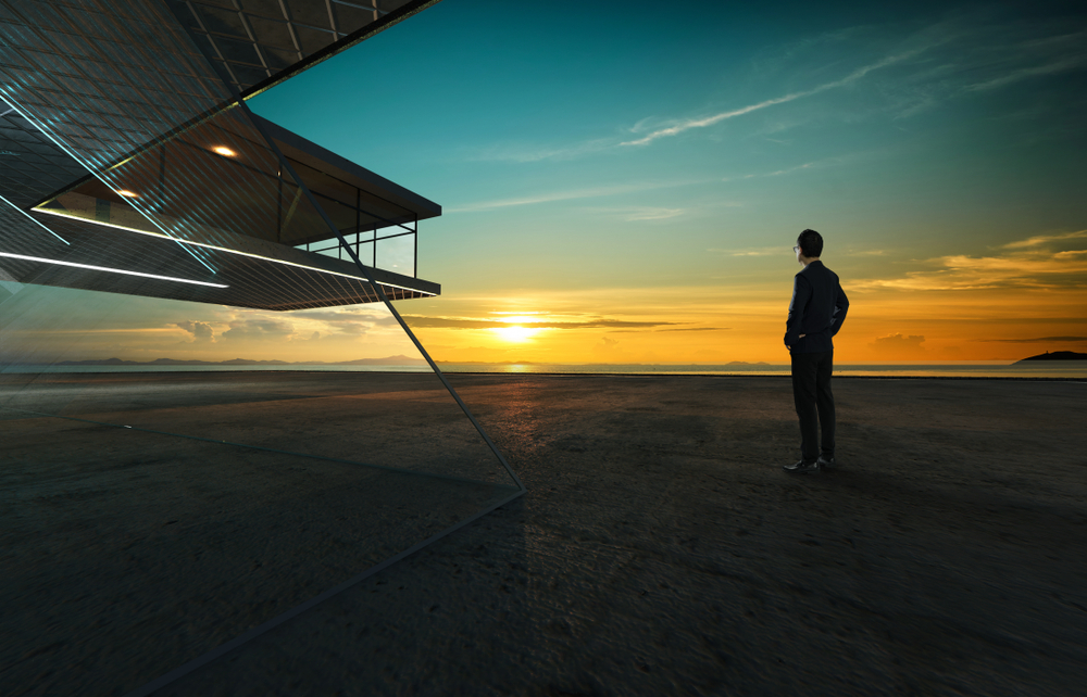 Businessman,Looks,At,Sunrise,Thoughtfully,With,Steel,And,Glass,Facade