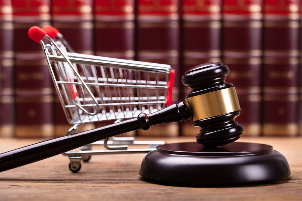 Close-up,Of,Brown,Gavel,And,Shopping,Cart,In,Front,Of