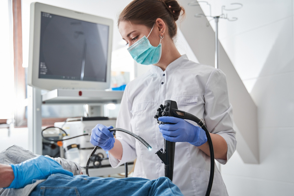 Female,Doctor,Wearing,Protective,Mask,Holding,Endoscope,During,Gastroscopy